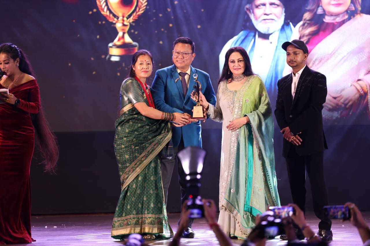 Yumme Momos receiving the Best Momo Manufacturer award on stage
